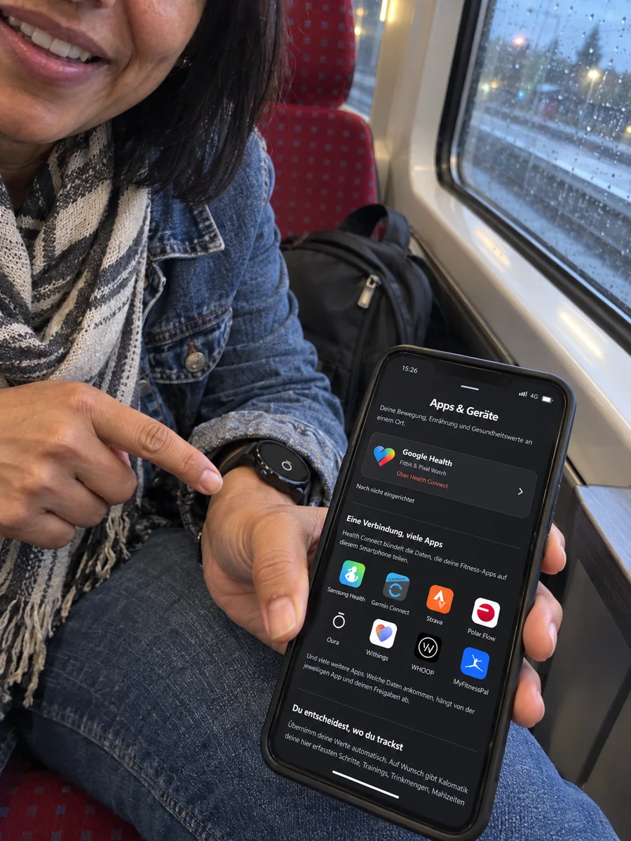 Unterwegs im Zug: Handy mit App-Verbindungen und Smartwatch am Handgelenk.